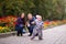 Happy family: Father, Mother and child - little girl in autumn park: playing in the alley with flowers