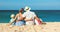 Happy family father, mother and children backs on beach at sea