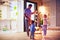 Happy family, father with sons decorate open space patio area with christmas garlands