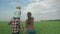 Happy family in field, young daddy with child boy on shoulders and mom walk in green grain field