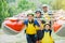 Happy family of four in helmet and live vest ready for rafting on the catamaran