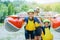 Happy family of four in helmet and live vest ready for rafting on the catamaran