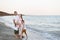 Happy family of four hugging on the sea coast. Parents, pregnant mother and two sons