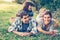 Happy family of four lying in the grass in autumn