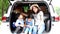 Happy family getting ready for road trip on a holiday. Happy asian children and Mother with shiba inu sitting and Sing Song in car