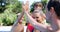 Happy family giving high five to each other near pool side