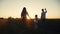 Happy family goes for a walk in the park on silhouette at sunset. daughter holds mom and. people in the park concept