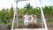 Happy family of grandad and grandson child swing together in backyard, swinging