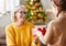 Happy family granddaughter gives a cheerful smiling grandmother a Christmas gift