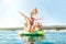 Happy family grandfather sliding down with hands up on floating Playground slide Catamaran as his multigeneration family enjoying