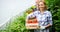 Happy family growing organic vegetables at farm, greenhouse