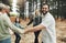 Happy family, hands and dance in forest with girl, parents and grandparents dancing in a circle in nature. Family, kids