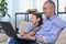 Happy family, happy dad and daughter laugh and watch cartoons, funny programs in a laptop during quarantine. Leisure, fun, online