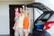 Happy family with hatchback car at home parking