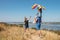 Happy family have fun playing with a kite in nature. The child sits on the shoulders of his father.