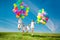 Happy family holding colorful balloons outdoor. Mom, ded and two