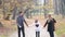 Happy family holding hands and walking in park