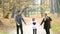 Happy family holding hands and walking in park