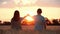 A happy family holds hands and looks at the sunset. A man and a woman hold hands. A couple in love