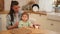 Happy family at home. Mother feeding her baby girl from spoon in kitchen. Little toddler child with messy funny face