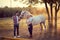 Happy family on the horse ranch .Young happy family having fun at countryside outdoors. Sunset. golden hour