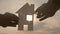Happy family house construction concept. man holding home a paper house in his hands at sunset lifestyle silhouette