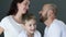 Happy family in identical white T-shirts hugs each other close up in studio on photo shoot
