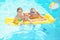 Happy family with inflatable mattress in swimming pool