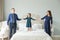 Happy family jumping on the bed. Mother, father, child daughter