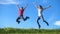 Happy family jumping on green grass hill at blue sky