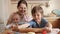 Happy family with kids rolling dough for biscuits or pie on kitchen. Children cooking with parents, little chef, family