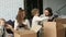 Happy family with kids unpacking boxes on living room couch