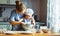 Happy family in kitchen. mother and child preparing dough, bake