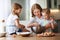 Happy family in kitchen. mother and children preparing dough, bake cookies