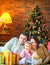 Happy family lies on the floor near the festive Christmas tree