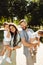 Happy family with little kids at the park, loving dad hold in arms adorable daughter, beautiful mom hold joyful son