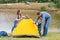 Happy family with little son set up camping tent. Happy childhood, camping trip with parents. A child helps to set up a tent