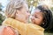 Happy family, love and interracial mother and girl hug at a park, happy and relax while bonding, laughing and having fun