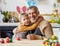 Happy family loving grandfather and cute little boy grandson embracing while painting Easter eggs