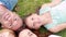 Happy family lying on grass and looking at camera