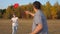 Happy family, man and woman play, throwing a flying red disc to each other in the park. Carefree couple, young people