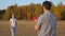 Happy family, man and woman play, throwing a flying red disc to each other in the park. Carefree couple, young people