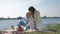 Happy family, merry mother braids hair child girl and communicate during relaxation on picnic on lawn