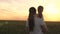 Happy family mom and daughter in the field at sunset. Mom and daughter walk past a wheat field and admire the sun's rays