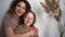 Happy family mom with teen daughter hugging laughing looking at camera, cheerful mother embracing child teenage girl