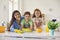 Happy family with mom and two children cleaning up at home. Parent and kids doing domestic chores together indoors