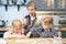 Happy family mom and two cute daughters preparing homemade cookies in the kitchen