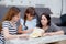 happy family mother, aunt, freind and daughter teaching read a book.