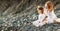 Happy family mother and child doing yoga, meditate in lotus position on beach