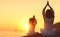 Happy family mother and child doing yoga, meditate in lotus position on beach